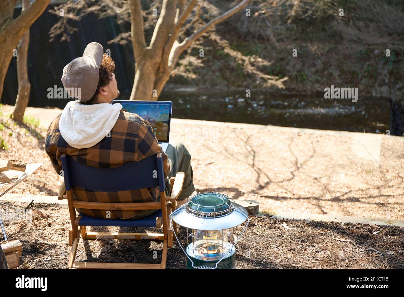 Mann, der auf dem Wintercampingplatz am Computer arbeitet Stockfoto