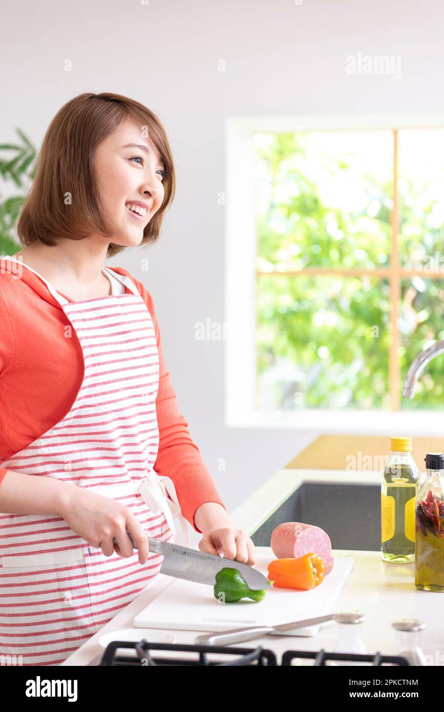 Eine Frau in ihrer 20s, die in der Küche kocht Stockfoto