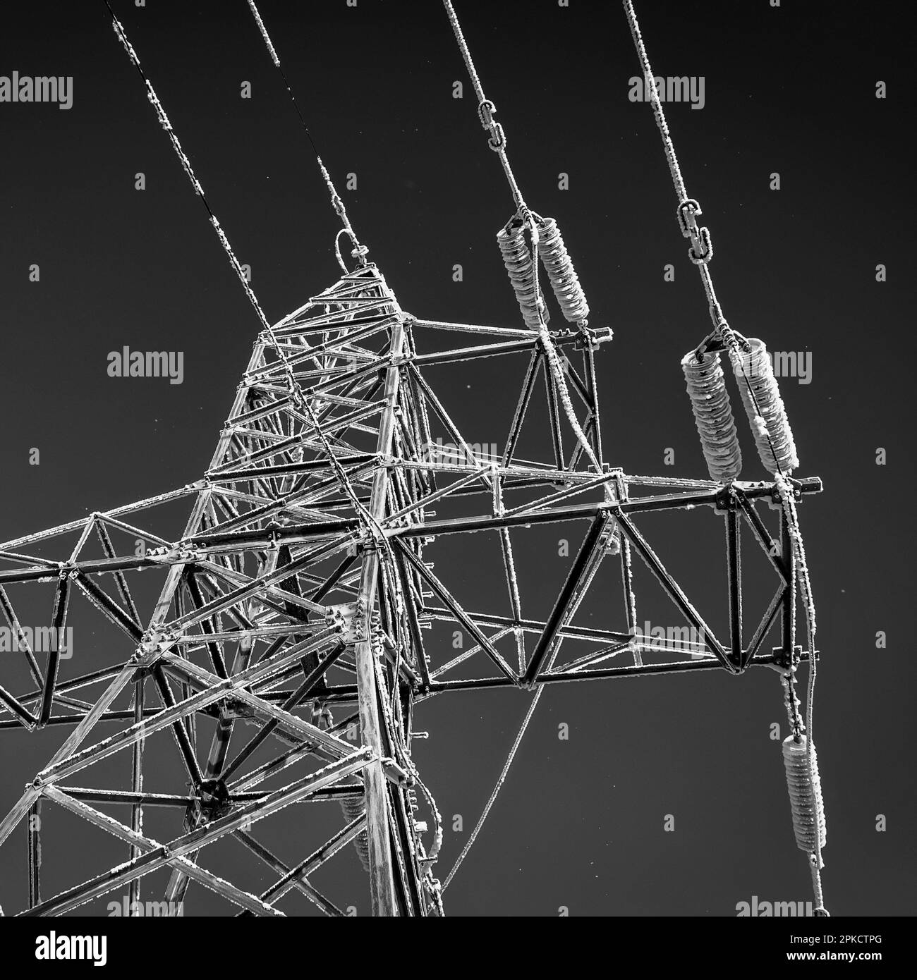 Hochspannungsleitungen und -Pole sind an einem frostigen Wintertag mit Frost bedeckt. Stockfoto