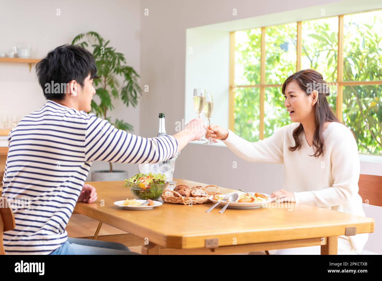 Ein Paar in den 30s Jahren, das an seinem freien Tag mit Champagner toast Stockfoto