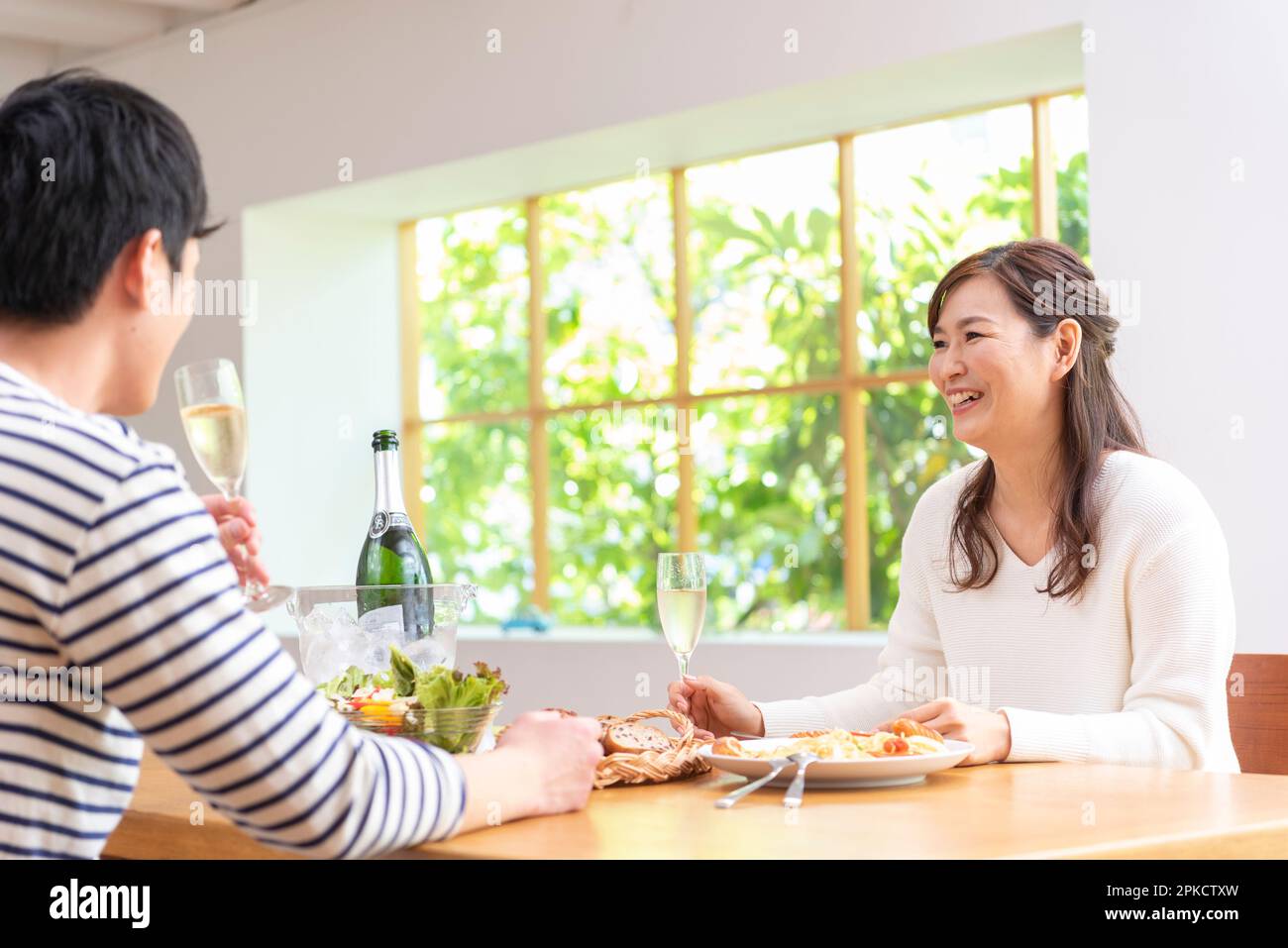 Ein Paar in den 30s, das Champagner trinkt und an seinem freien Tag zu Mittag isst Stockfoto