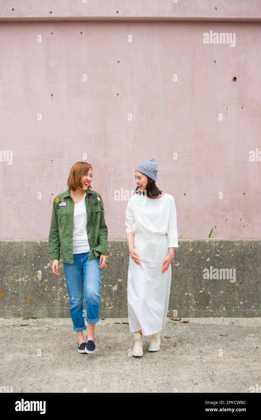 2 Frauen in ihren 20s, die mit Freunden reden Stockfoto