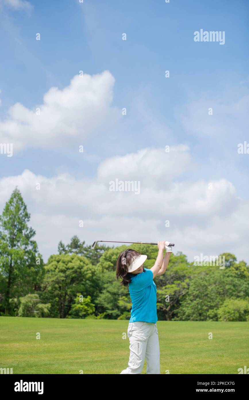 Eine Frau mittleren Alters, die Golf spielt Stockfoto