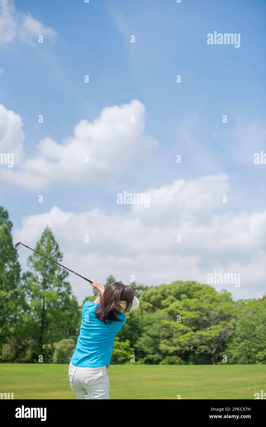 Eine Frau mittleren Alters, die Golf spielt Stockfoto