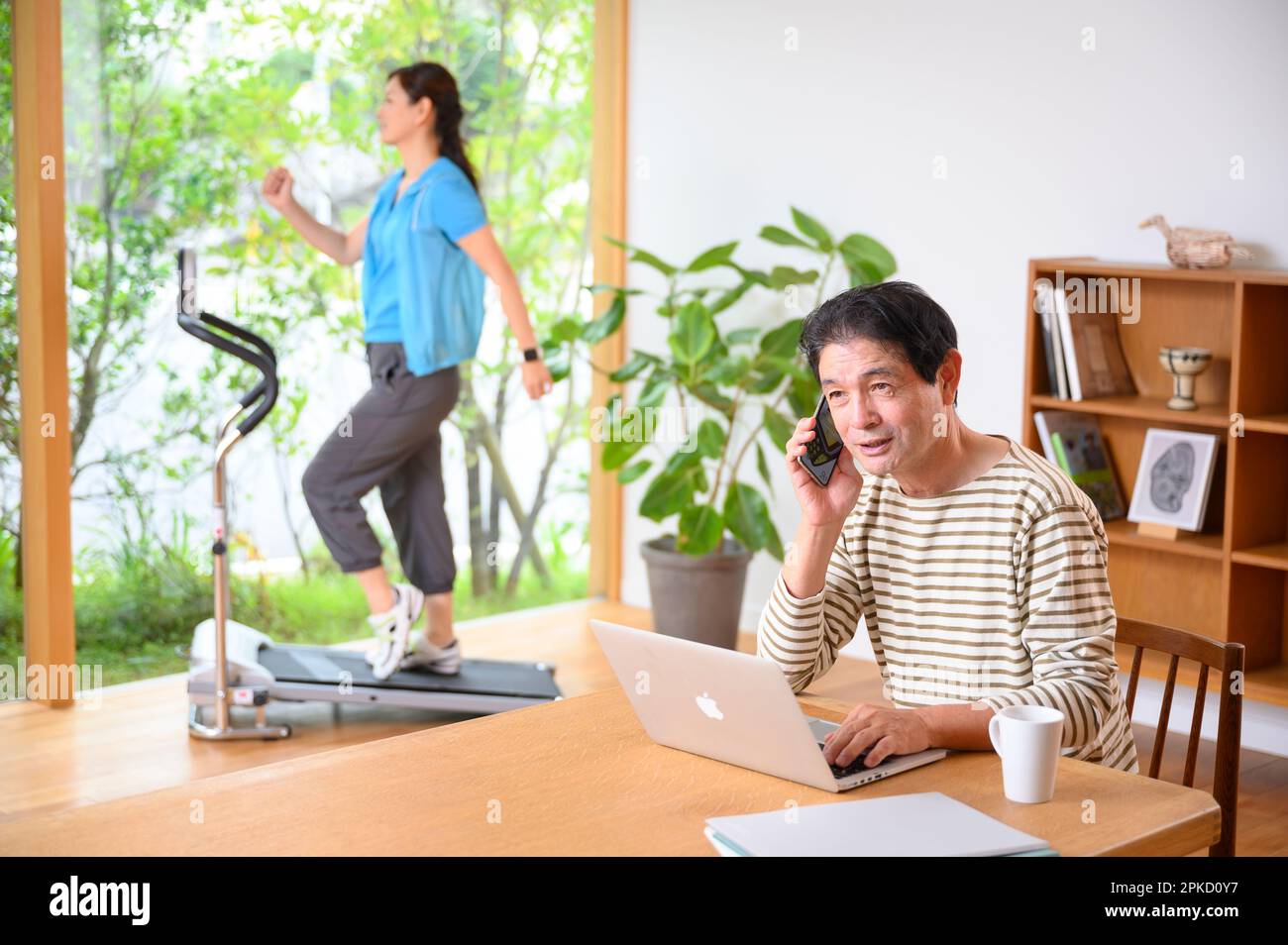 Telearbeit, Mann und Frau mittleren Alters, die Laufmaschine spielen Stockfoto
