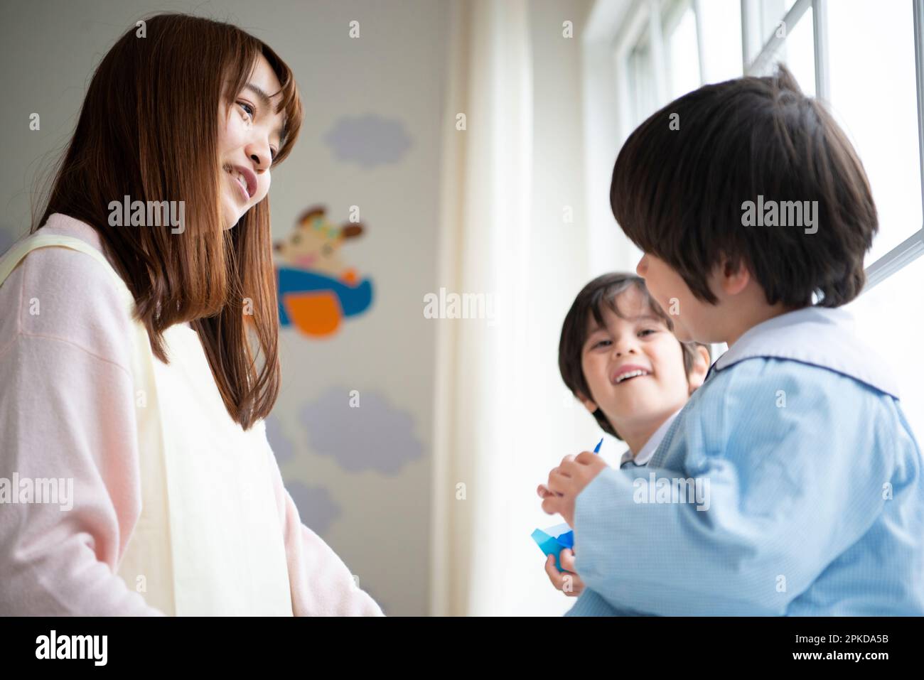 Lächelnde Kindergärtnerin und Vorschulkinder Stockfoto