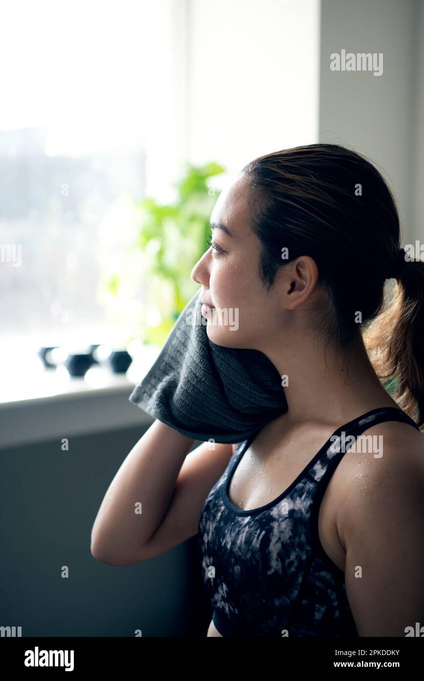Eine Frau, die eine Pause macht, während sie im Fitnessstudio den Schweiß abwischte Stockfoto