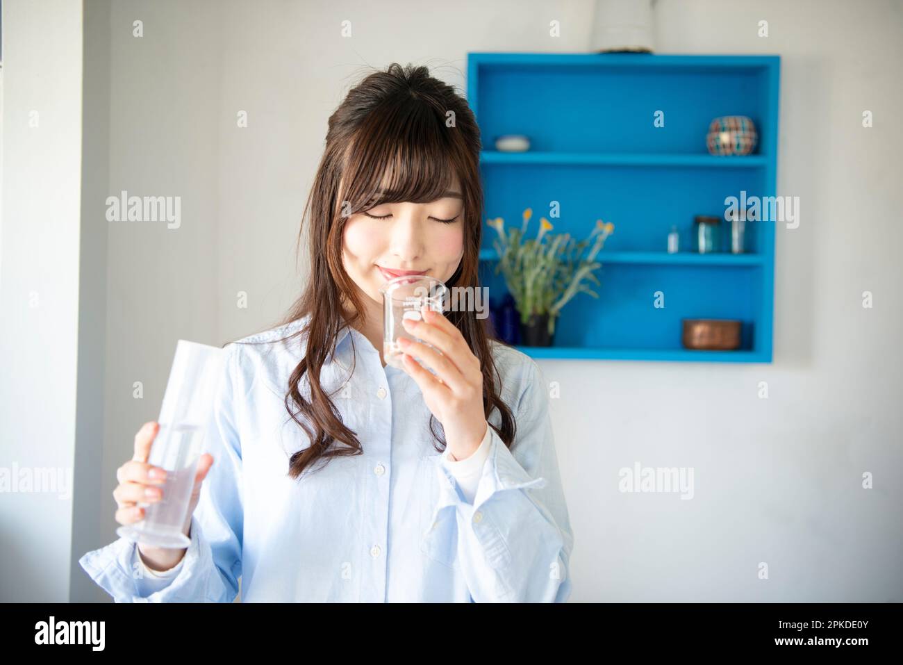 Eine Frau, die Aroma-Öl aus einem Becher riecht Stockfoto