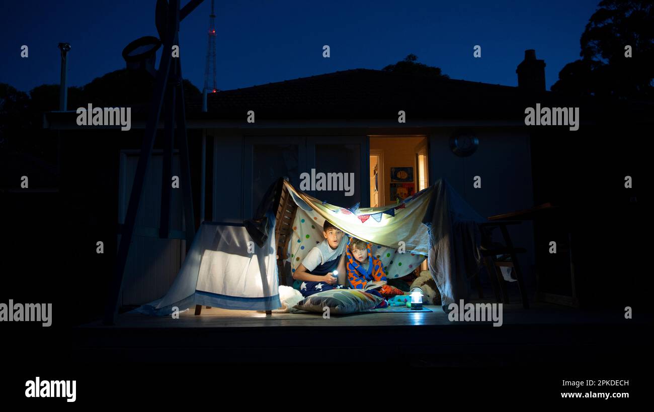 Brüder in einem Zelt aus Laken Stockfoto