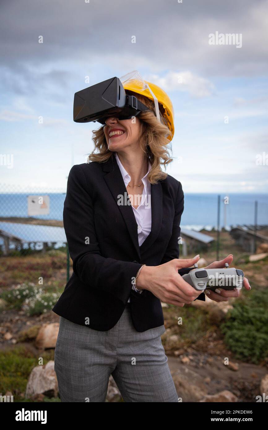 Ein Techniker verwendet VR-Headsets und eine Fernbedienung in einem Werk während einer Inspektion Stockfoto
