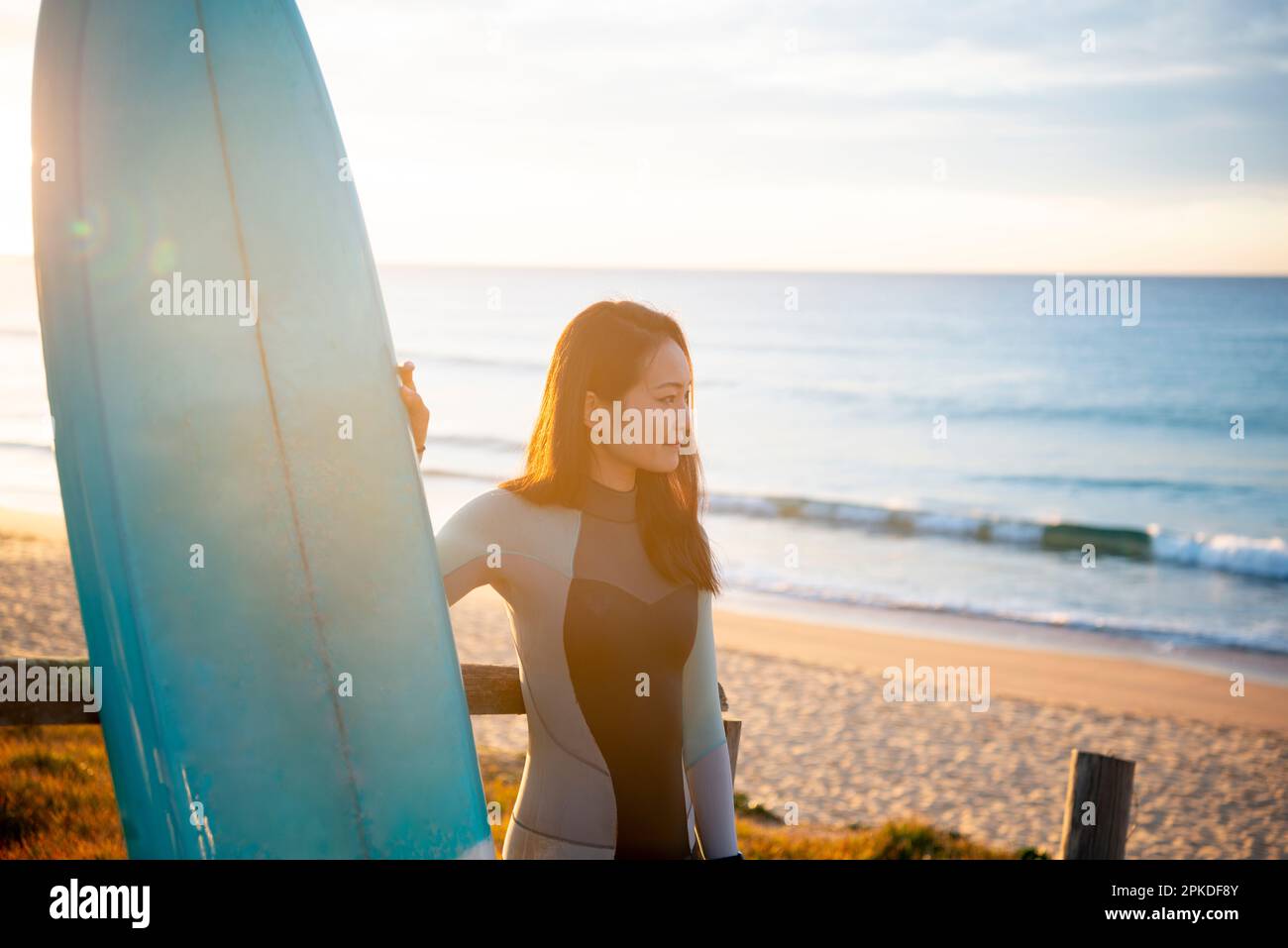 Frau in Surfbrett und Neoprenanzug Stockfoto