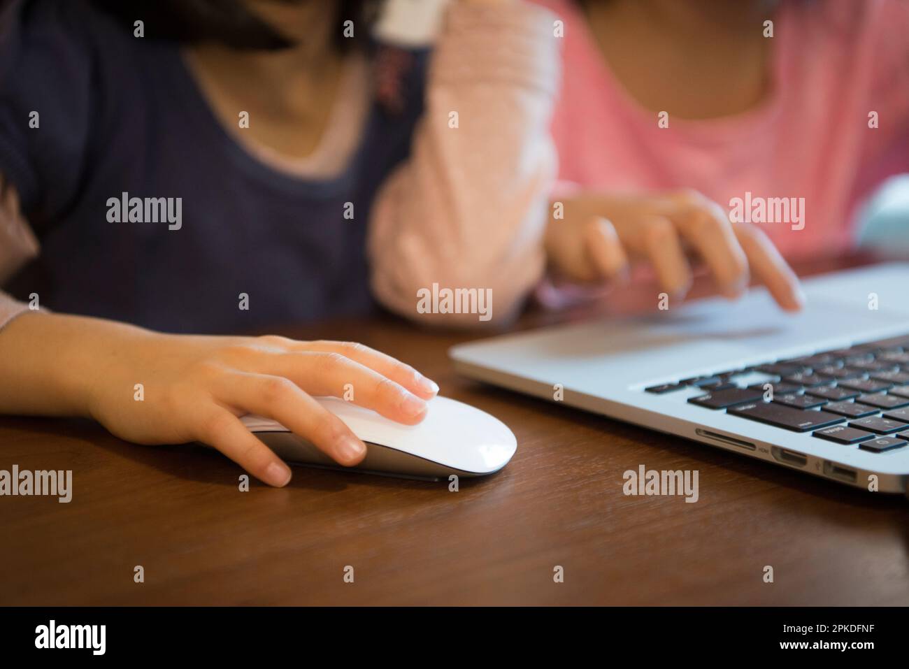 Kinderhände bedienen eine Computermaus Stockfoto