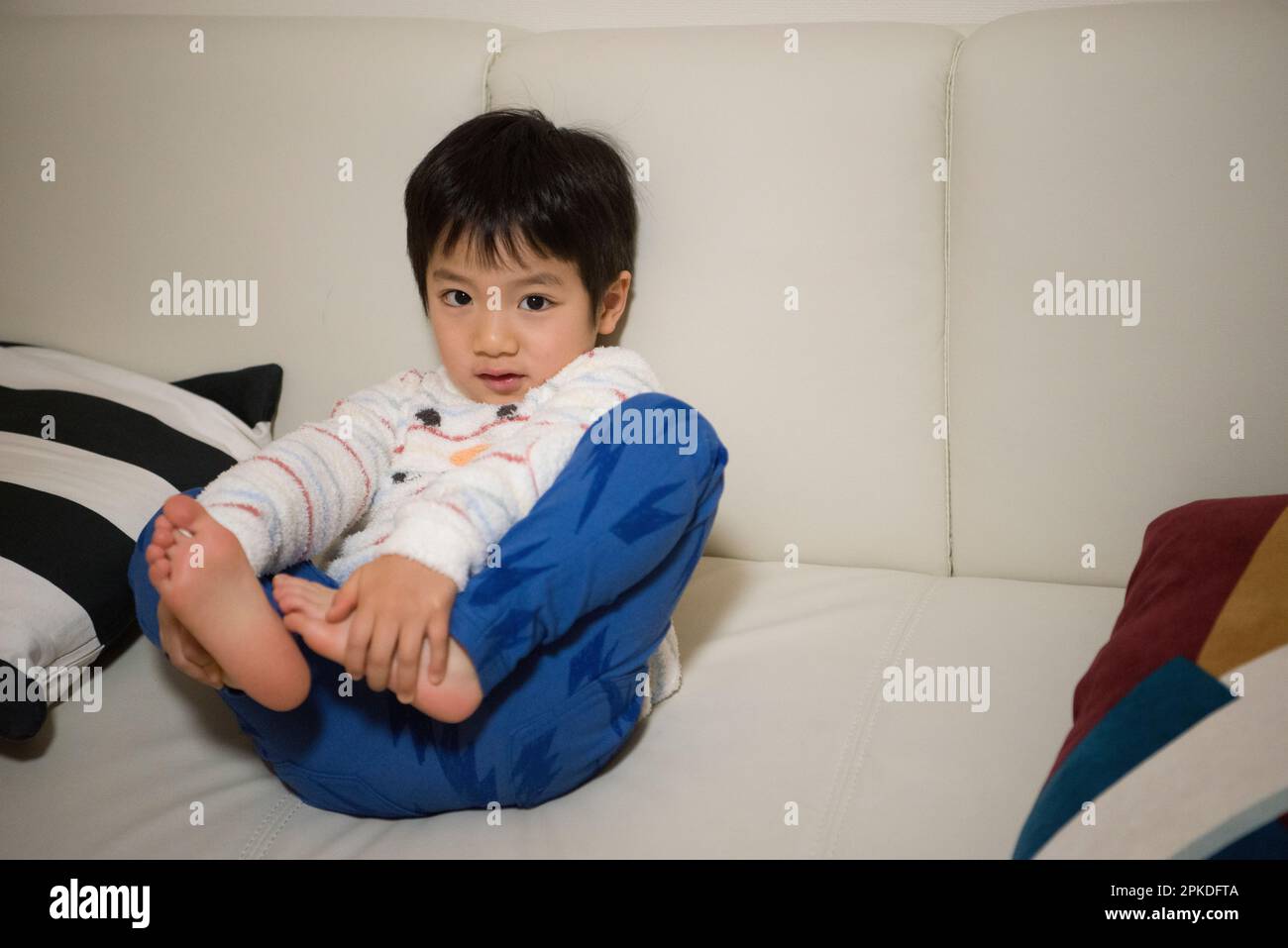 Der Junge sitzt auf der Couch Stockfoto