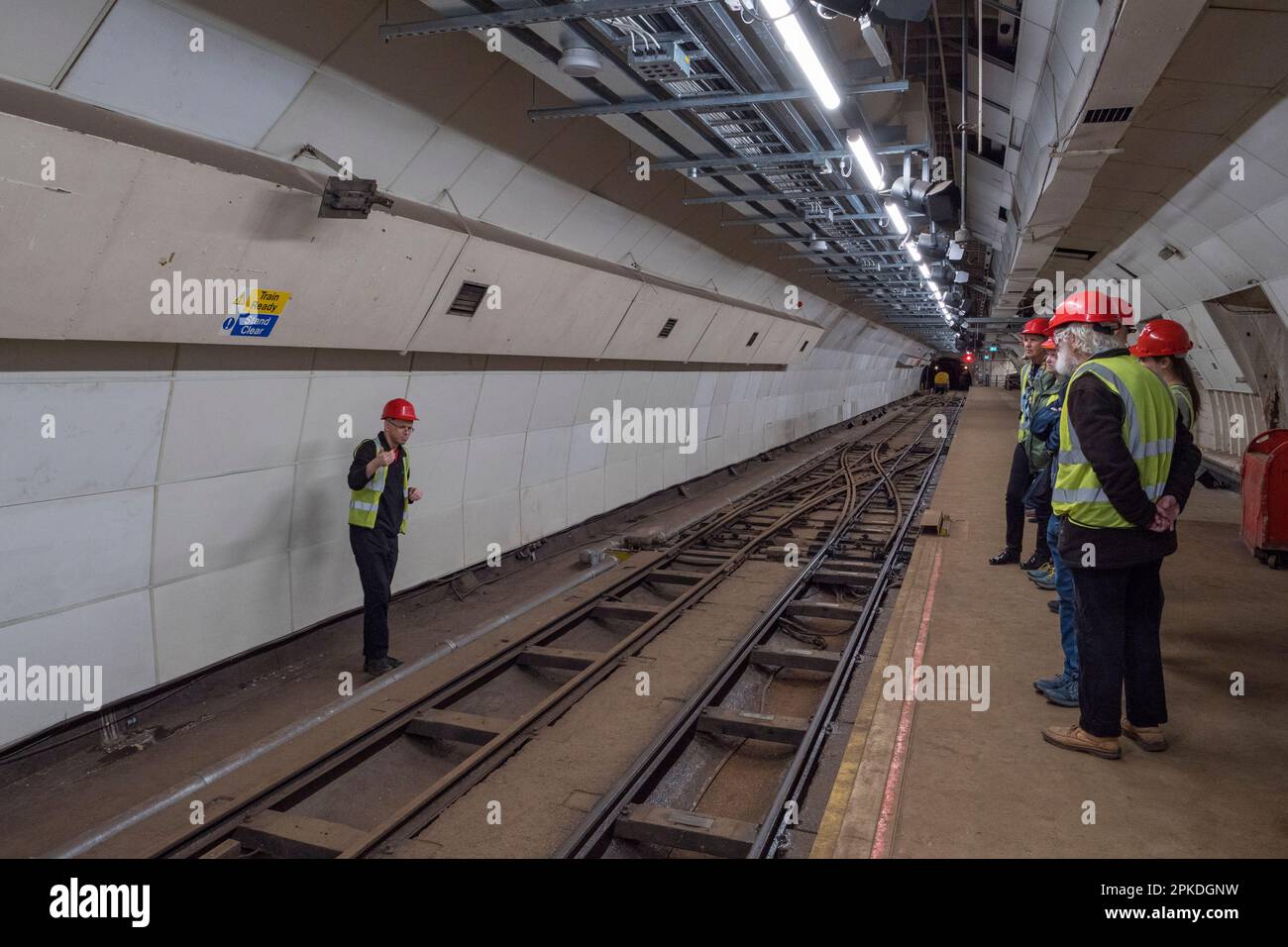 Tour-Gruppe auf dem Bahnsteig Mount Pleasant auf der Post Rail, dem ehemaligen Postamt-Eisenbahnsystem unter den Straßen des Zentrums von London, Großbritannien. Stockfoto