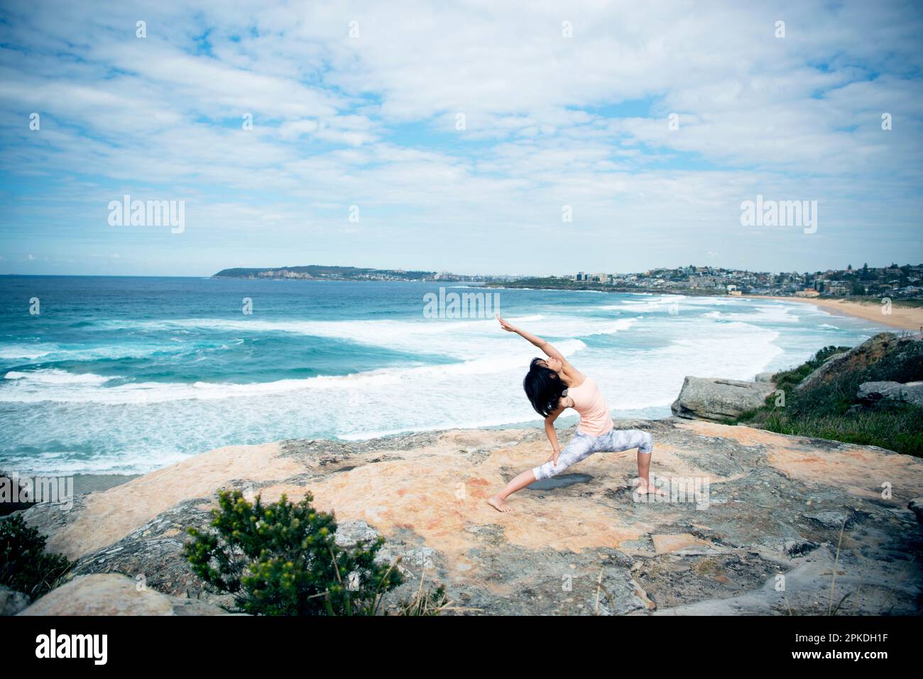 Eine Frau, die Yoga im Meer macht Stockfoto