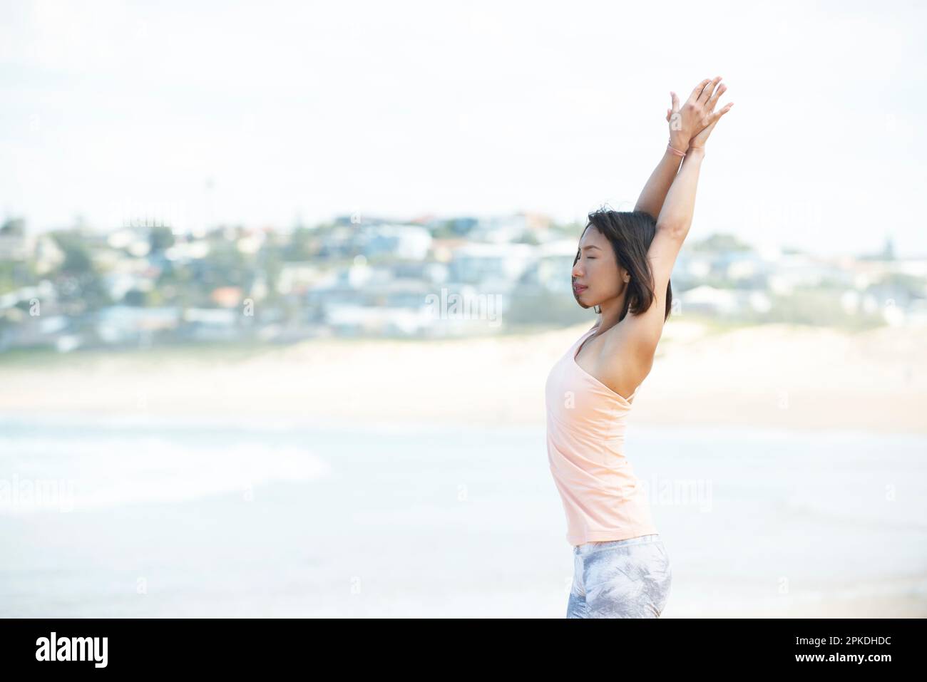 Eine Frau, die Yoga im Meer macht Stockfoto