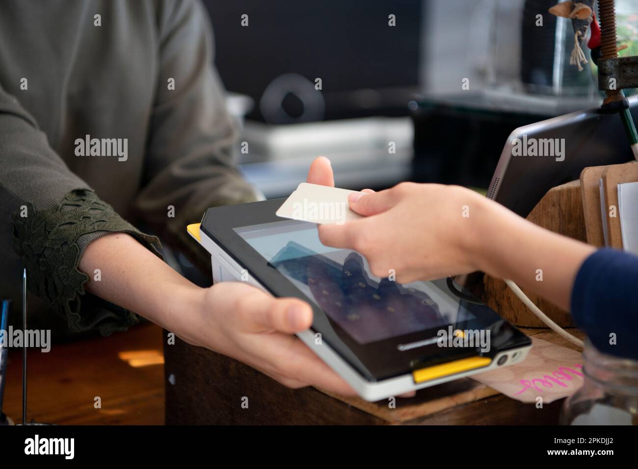 Eine Frau, die eine elektronische Zahlung in einem Laden macht Stockfoto