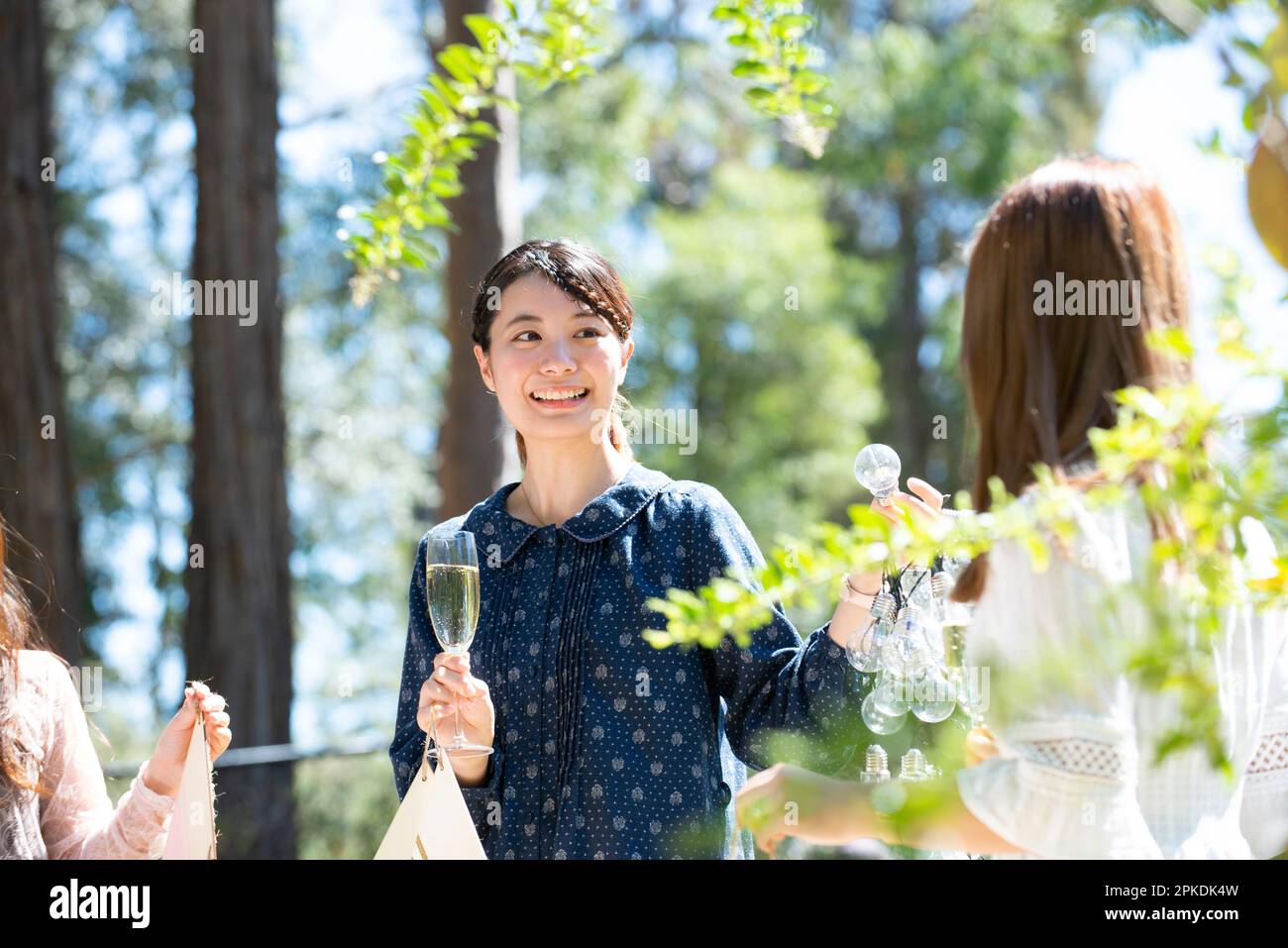 Drei Frauen genießen eine Gartenparty mit einem Lächeln im Gesicht Stockfoto