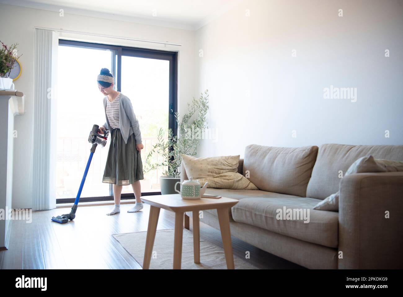 Eine Frau, die im Wohnzimmer saugt Stockfoto