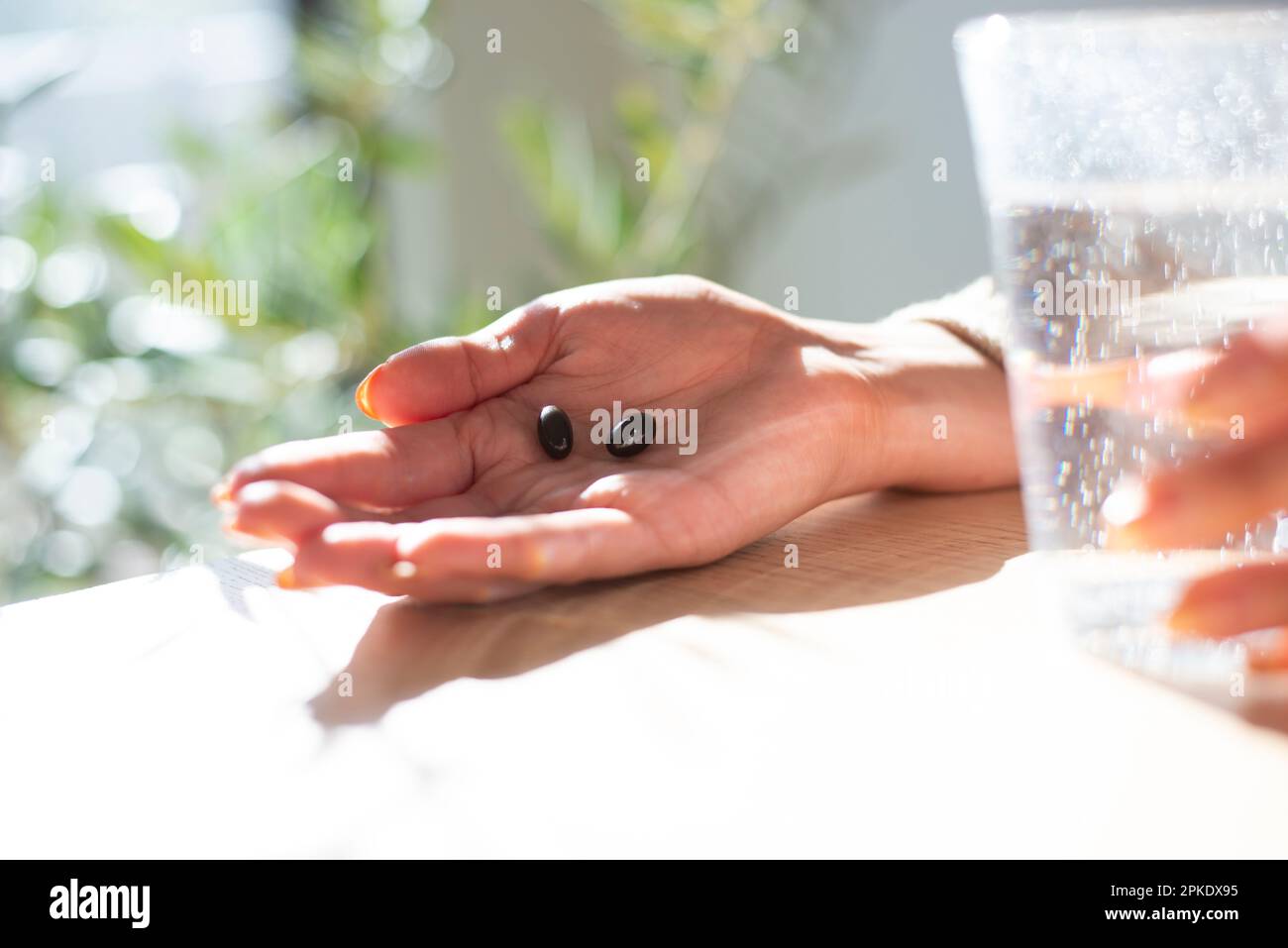 Handhaltezusatz und ein Glas Wasser Stockfoto