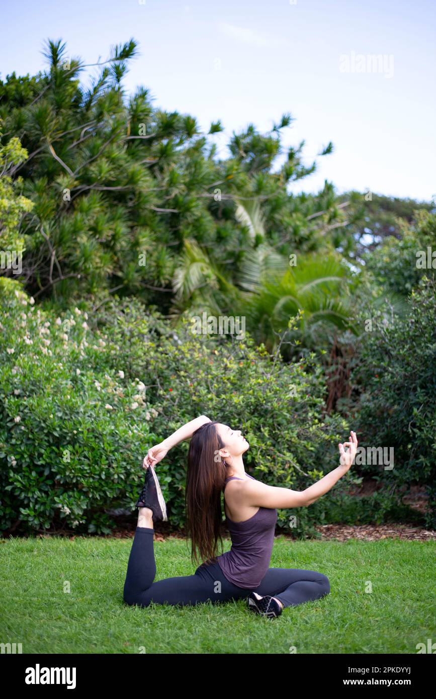Frau yoga Pose in Park Stockfoto