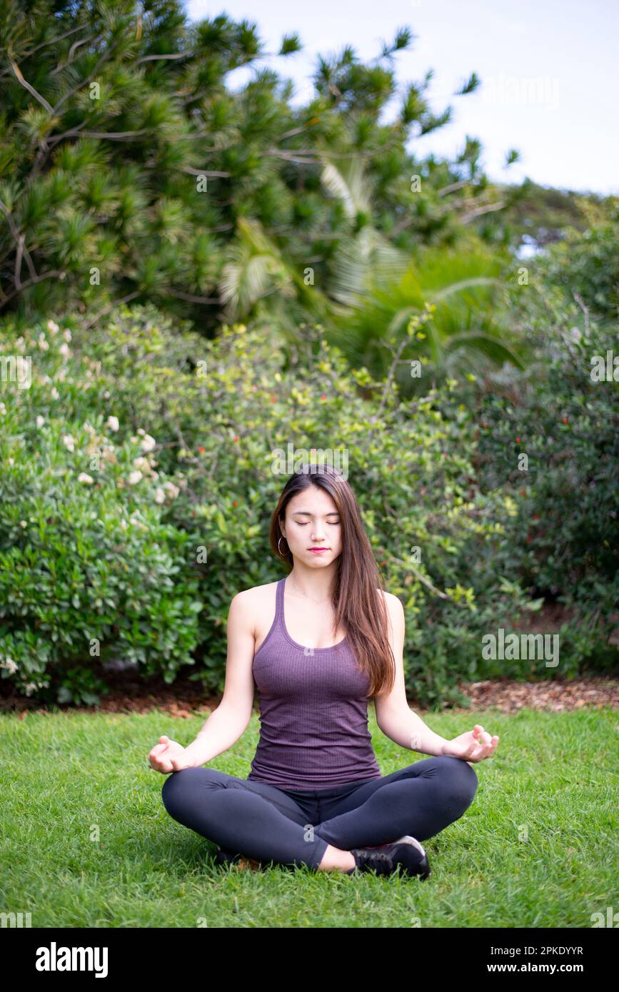 Eine Frau, die im Park meditiert Stockfoto