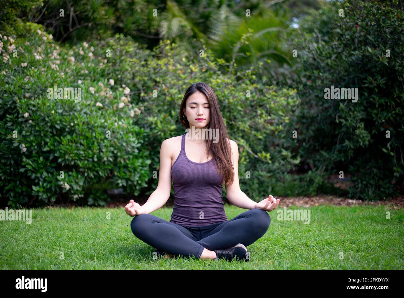 Eine Frau, die im Park meditiert Stockfoto