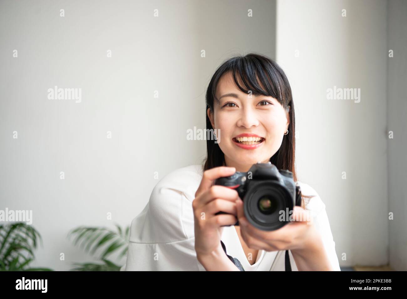 Lächelnde Frau mit einer Spiegelreflexkamera Stockfoto