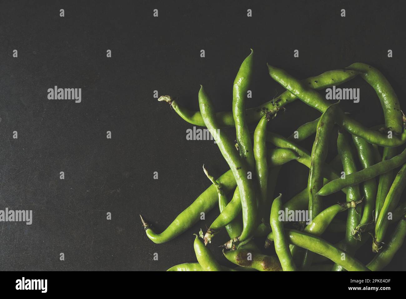 Frische grüne Faba-Bohnen auf schwarzem rustikalem Hintergrund, Tischaufnahme Stockfoto
