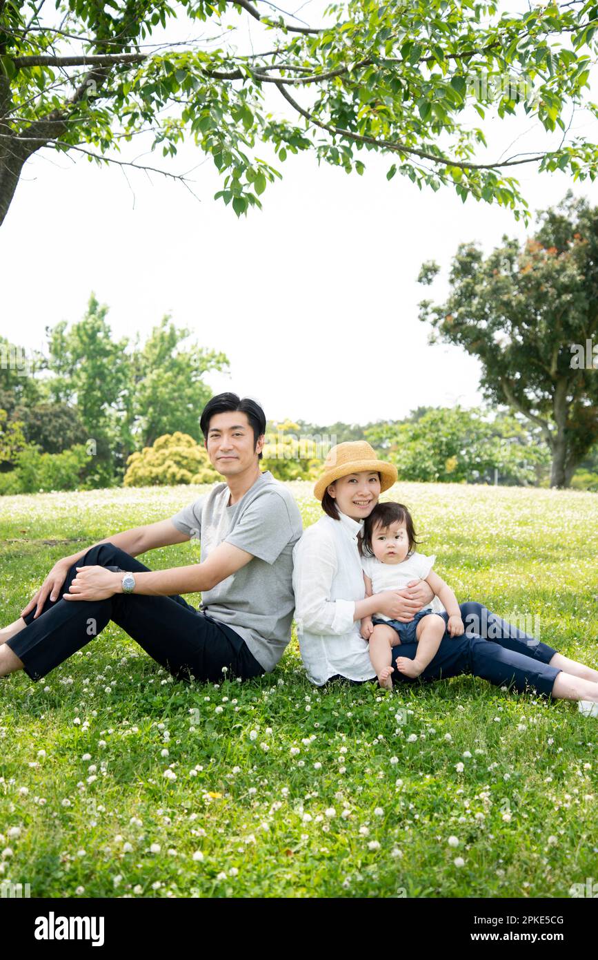 Familie Sitzt Auf Rasen Stockfoto
