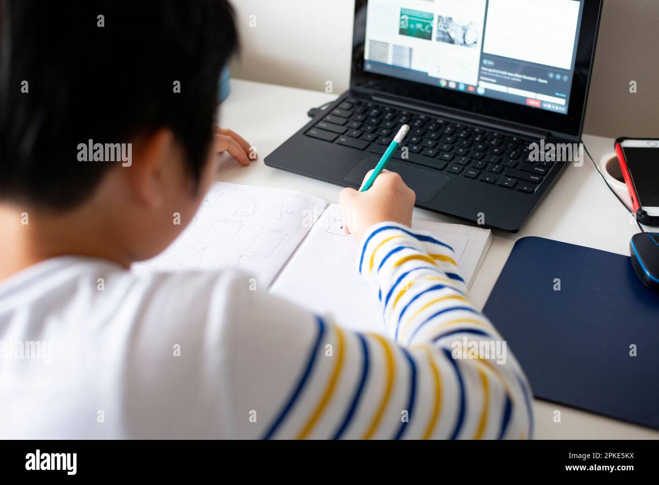 Ein Junge, der vor dem Computerbildschirm lernt Stockfoto