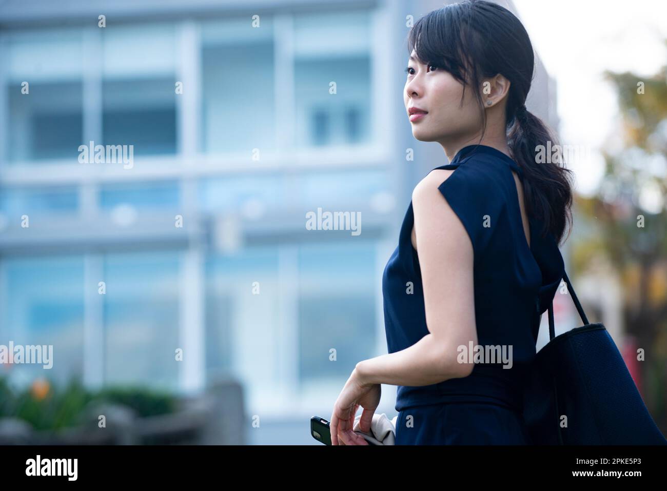 Eine Frau, die vor dem Gebäude zurückblickt Stockfoto