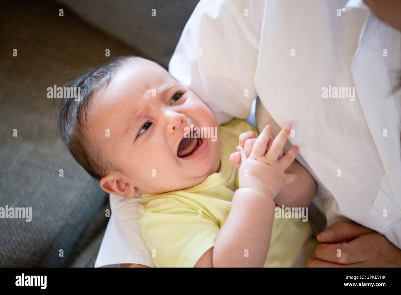 Weinendes Baby, das getragen wird Stockfoto