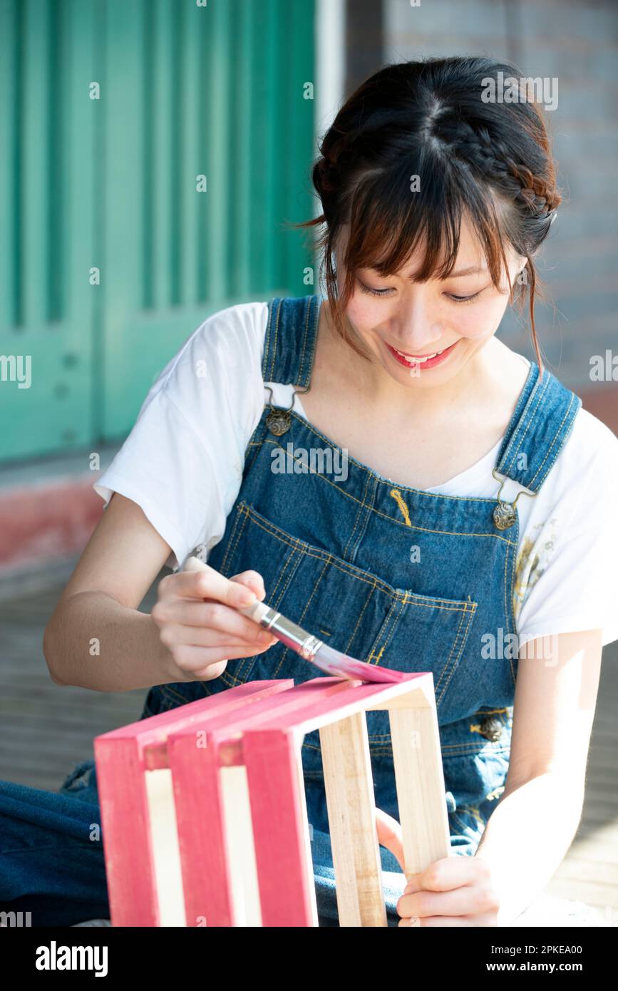 Eine Frau, die die Schachtel mit einem Pinsel malt Stockfoto