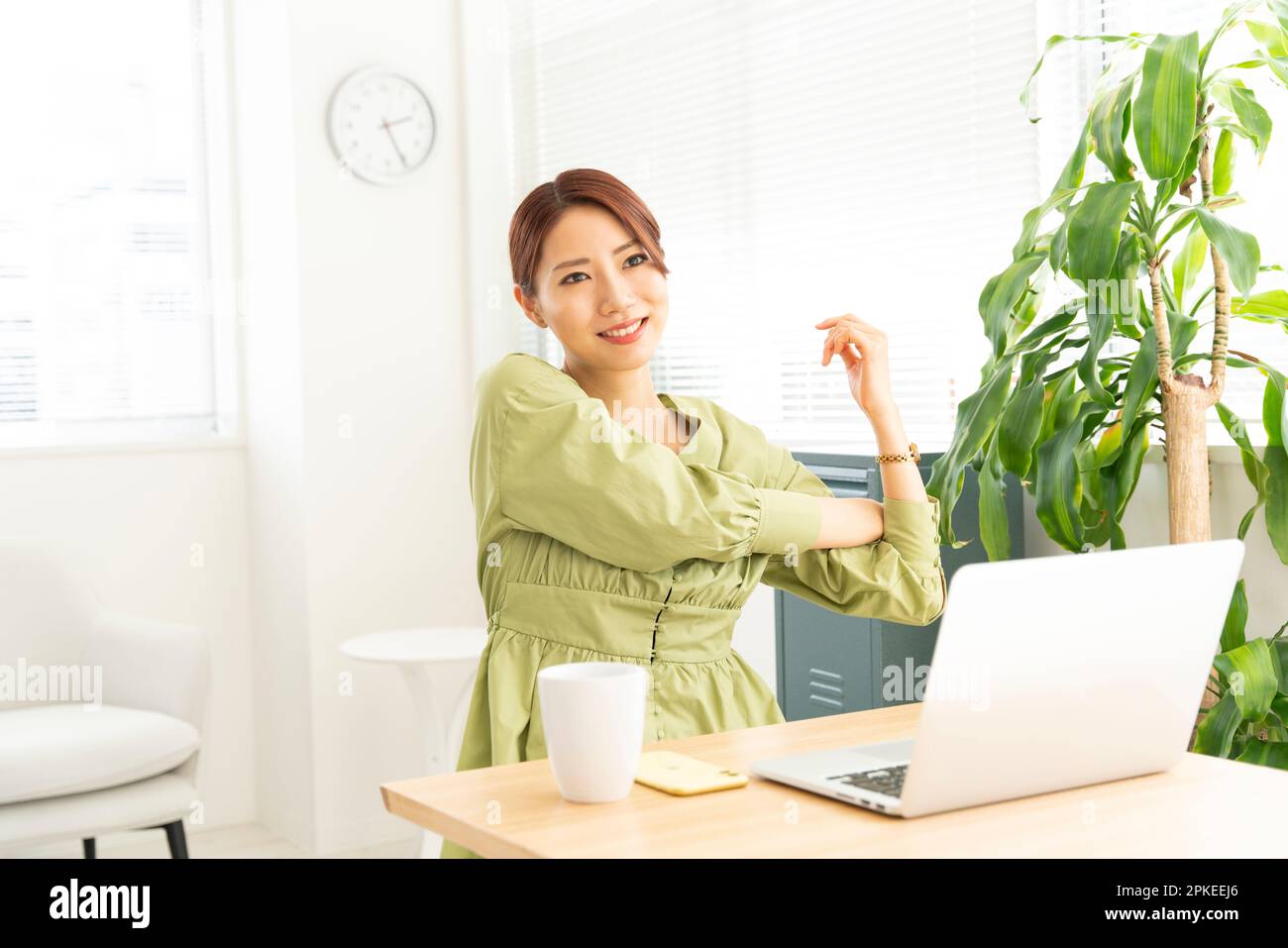 Frau, die sich vor dem Computer streckt Stockfoto