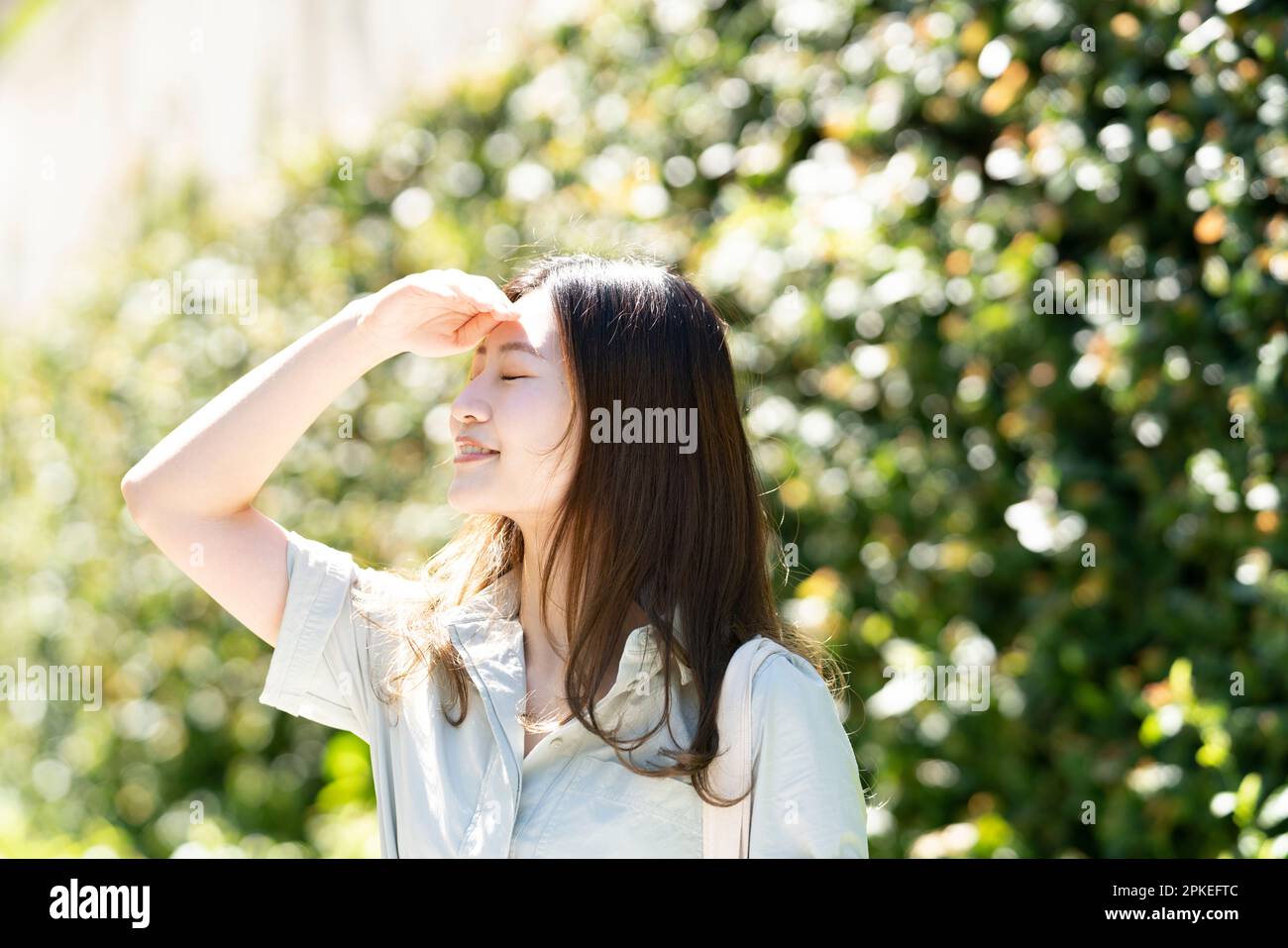 Eine Frau, die geblendet aussieht und das Sonnenlicht verdeckt Stockfoto