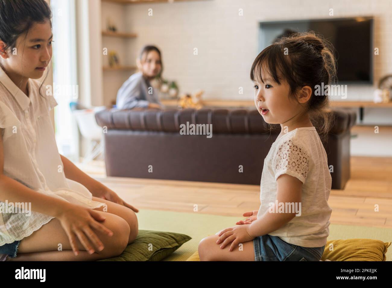 Schwestern, die mit ihrer Mutter im japanischen Zimmer spielen Stockfoto