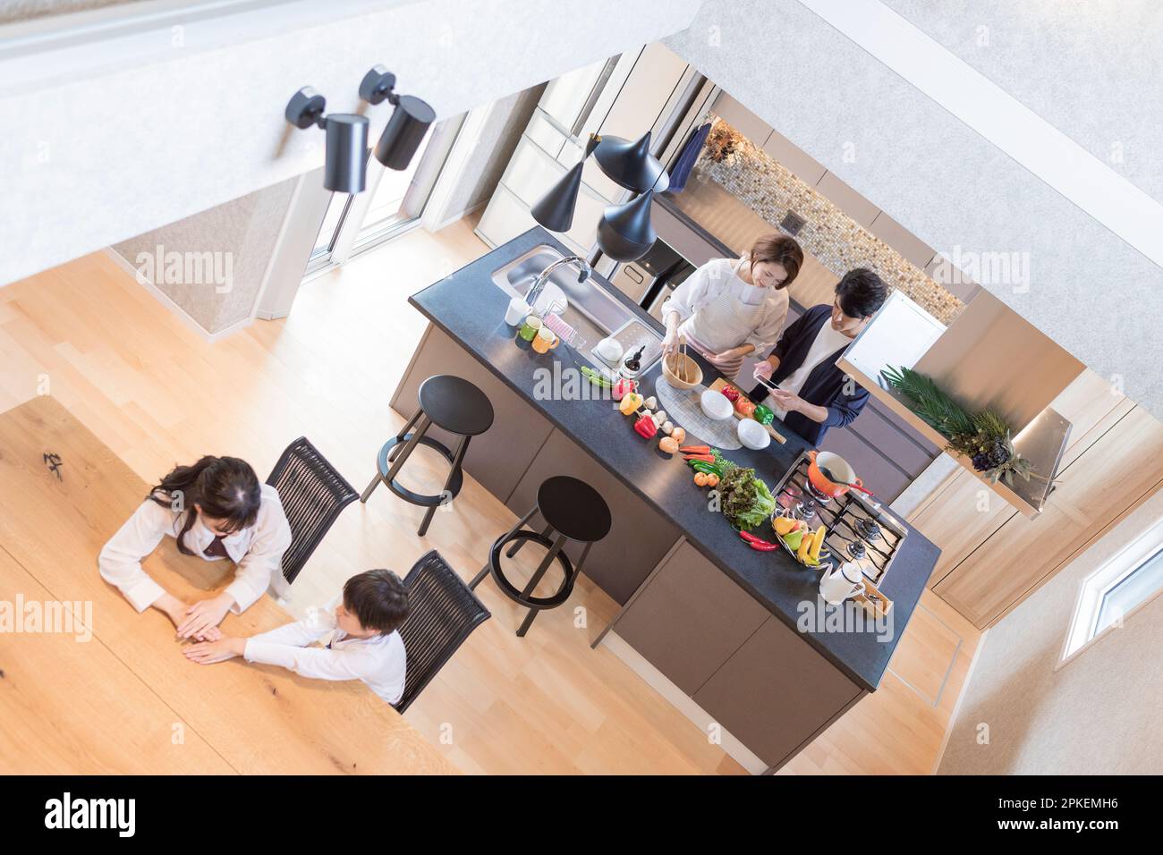 Ein Paar steht in der Küche mit einem sprechenden Bruder und einer sprechenden Schwester Stockfoto