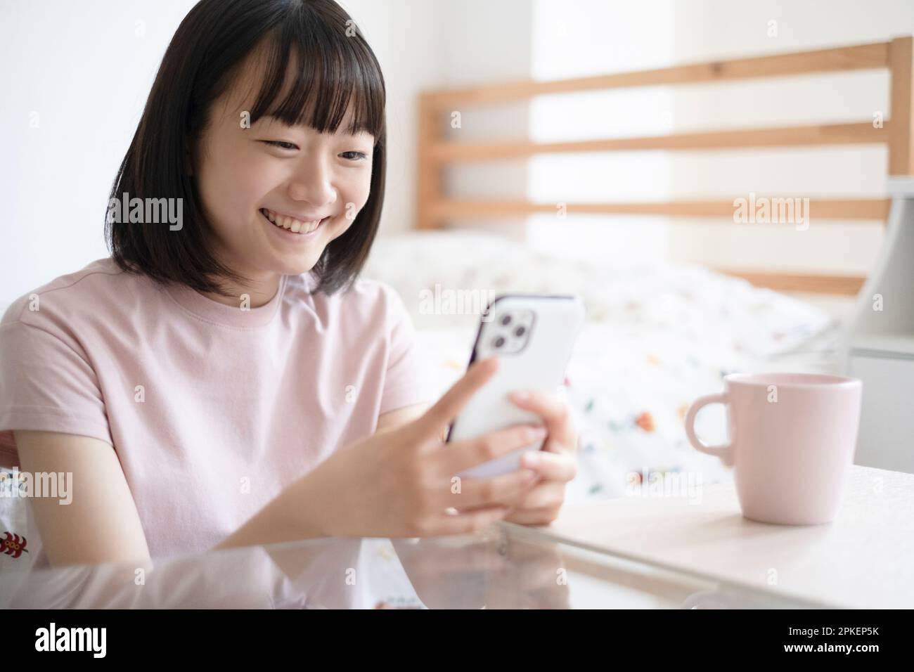 Ein Mädchen, das auf ein Smartphone schaut Stockfoto
