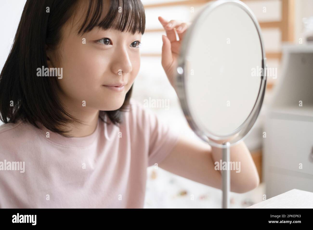 Ein Mädchen, das in den Spiegel schaut Stockfoto