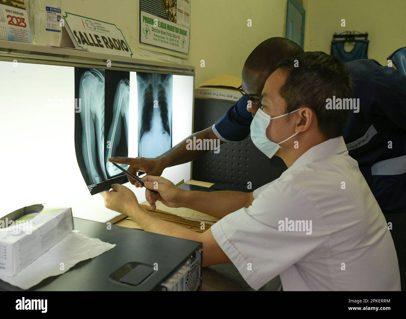 Dakar. 31. März 2023. Das chinesische Medizinteam-Mitglied Jiang Wenkuang arbeitet am 21. März 2023 mit einem örtlichen Arzt im Kinderkrankenhaus von Diamniadio in Dakar, Senegal, zusammen. Das 19. Chinesische Ärzteteam, das nach Senegal entsandt wurde, bietet seit November 2021 medizinische Dienstleistungen im Kinderkrankenhaus von Diamniadio an. Bis zum 31. März 2023 hatte das medizinische Team 7.058 ambulante Leistungen erbracht, 3.150 Operationen und 1.039 Narkosefälle abgeschlossen. Kredit: Han Xu/Xinhua/Alamy Live News Stockfoto