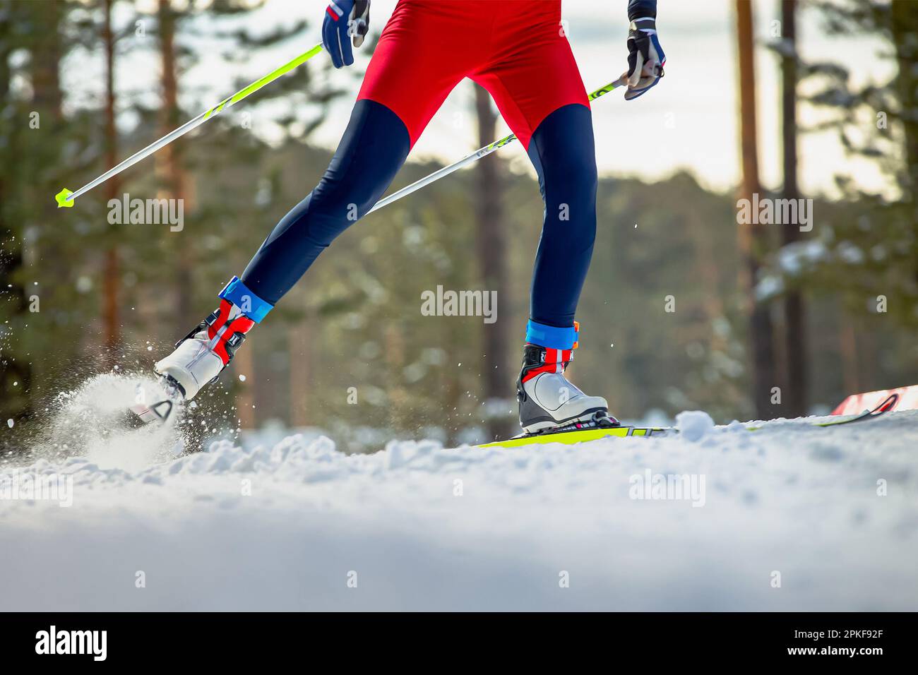 Beine Skifahrer auf der Skipiste, Schneespritzer unter Skiern und Stöcken, Wintersportwettbewerb Stockfoto