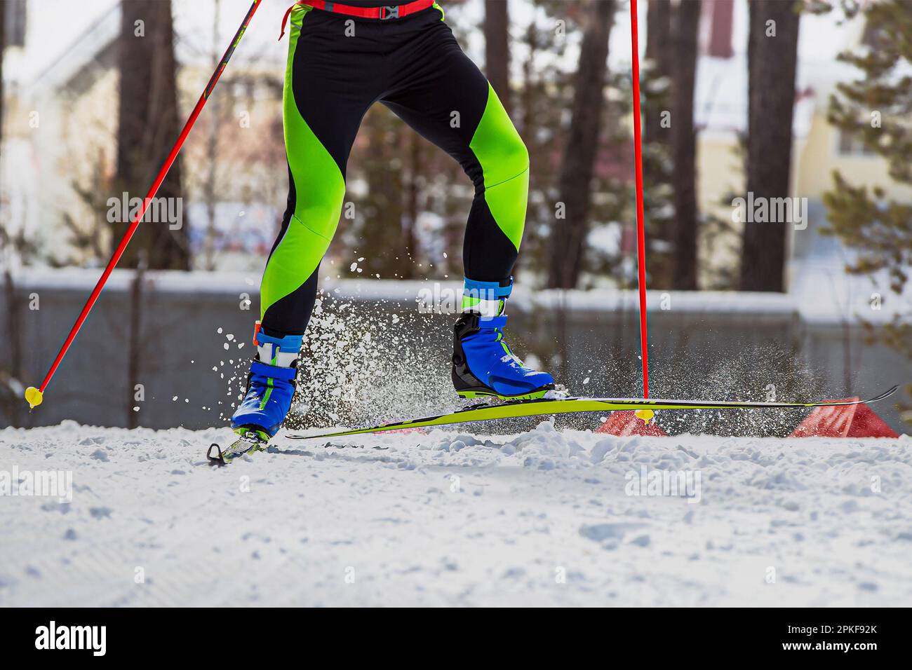 Nahaufnahmen der Beine Skifahrer laufen auf der Skipiste, Schnee spritzt unter Skiern und Stöcken, Wintersportwettbewerb Stockfoto