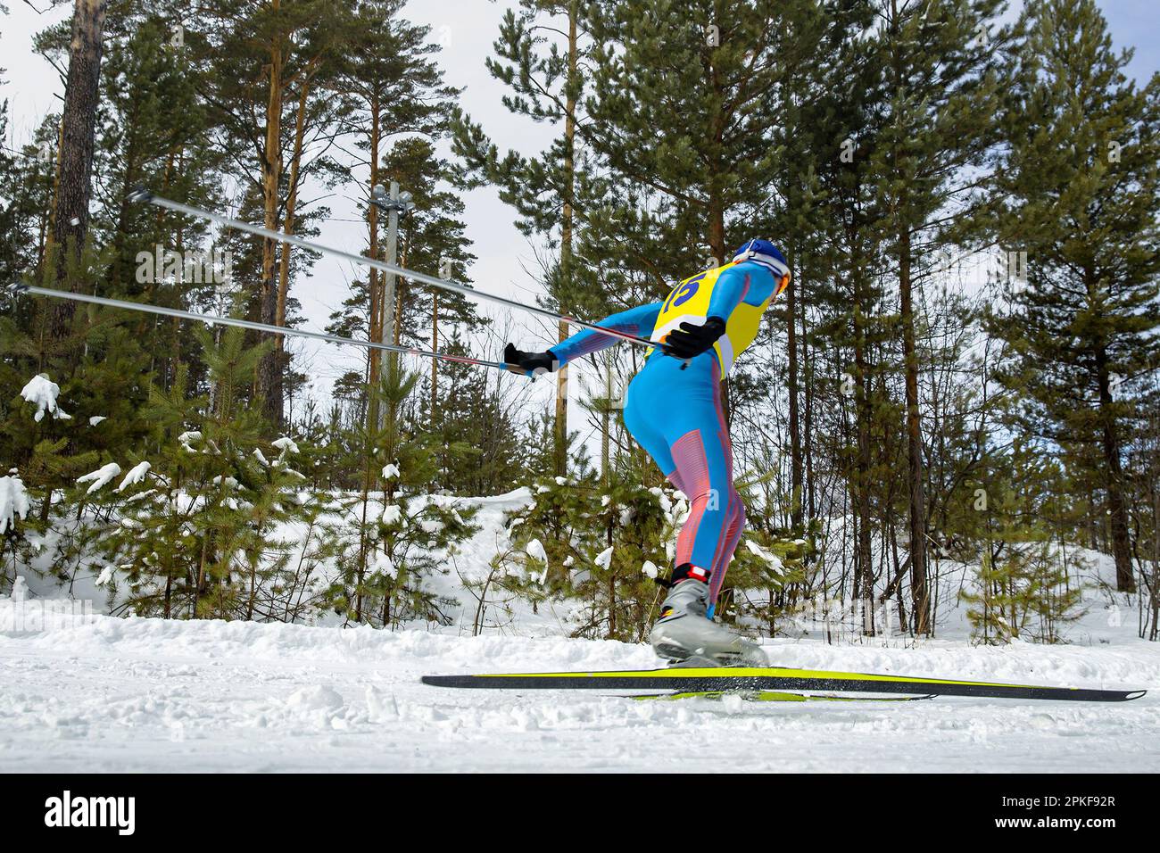 Männlicher Sportler, der Skilanglauf im Skating-Stil läuft, Wintersportwettbewerb Stockfoto