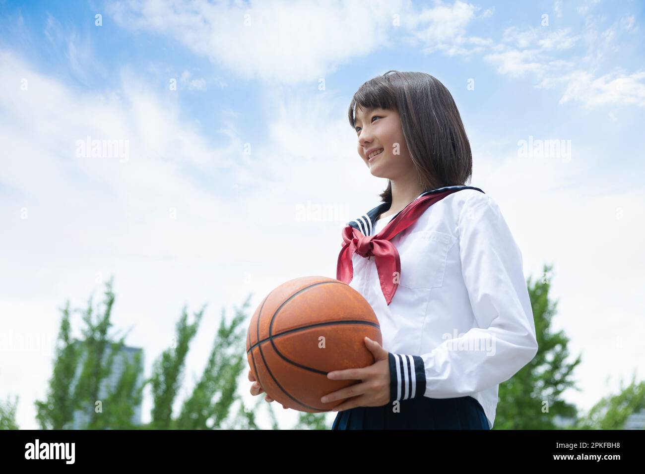 Junior High School Schülerin mit einem Basketball Stockfoto