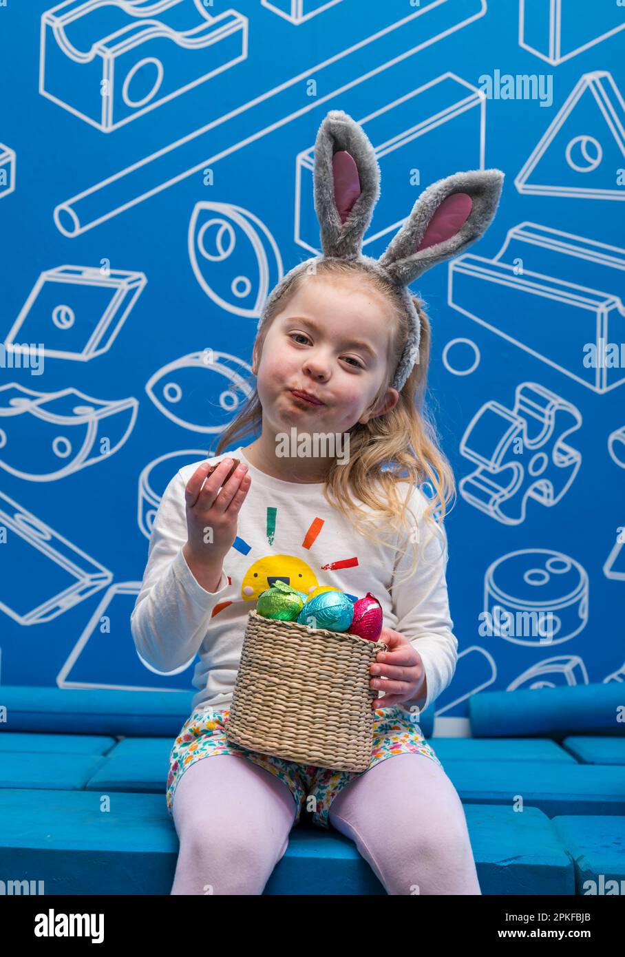 Ein junges Mädchen isst Schokoladen-Osterei beim Edinburgh Science Festival, Schottland, Großbritannien Stockfoto