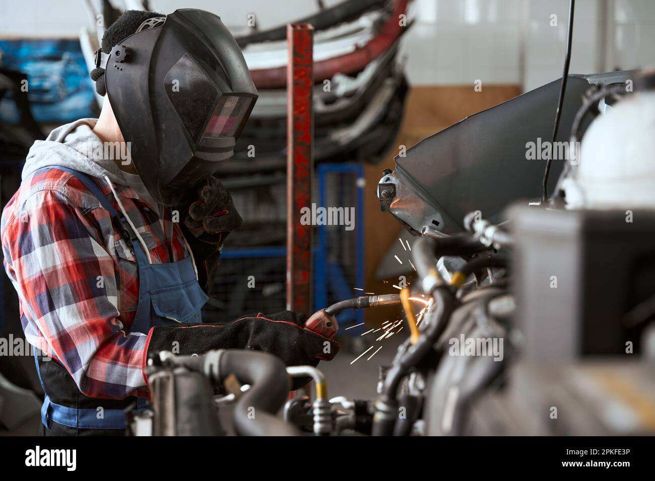 Fachschweißer für Schutzmaskenarbeiten in der Kfz-Werkstatt Stockfoto