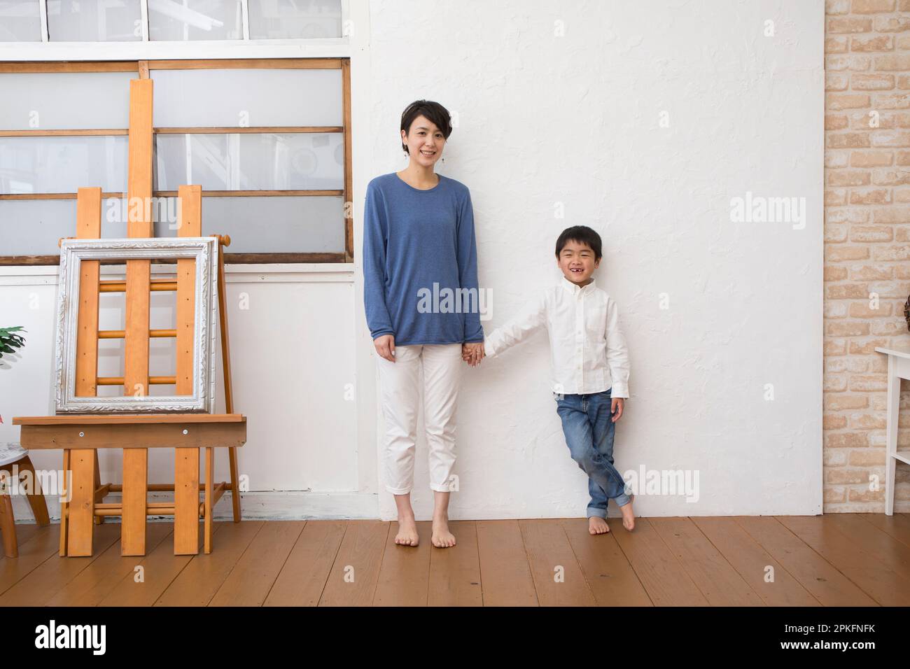 Mutter und Junge stehen vor der Wand in ihrem Zimmer Stockfoto