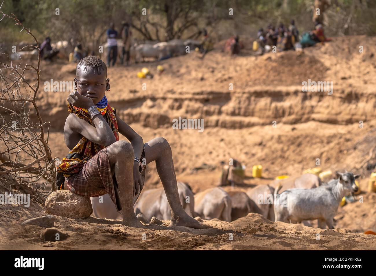 Kenia. 18. Februar 2023. Ein Kind aus dem Turkana-Stamm, das auf seine Familie wartet, nahe am Brunnen der Klimawandel verursacht in Ostafrika die schlimmste Dürre in seiner Geschichte: Es hat in dieser Region seit mehr als drei Jahren nicht mehr geregnet, und mehr als 36 Millionen Menschen sind mit den verheerenden Folgen einer Welle konfrontiert, die laut Prognosen nicht in absehbarer Zeit enden wird. In Turkana, nördlich von Kenia, kämpfen die Menschen, um diese schreckliche Dürre zu überleben. Kredit: SOPA Images Limited/Alamy Live News Stockfoto