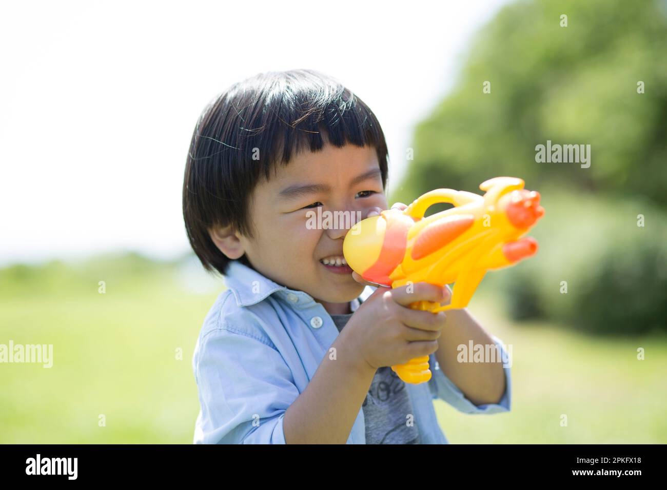 Der Junge zielt mit der Wasserpistole Stockfoto